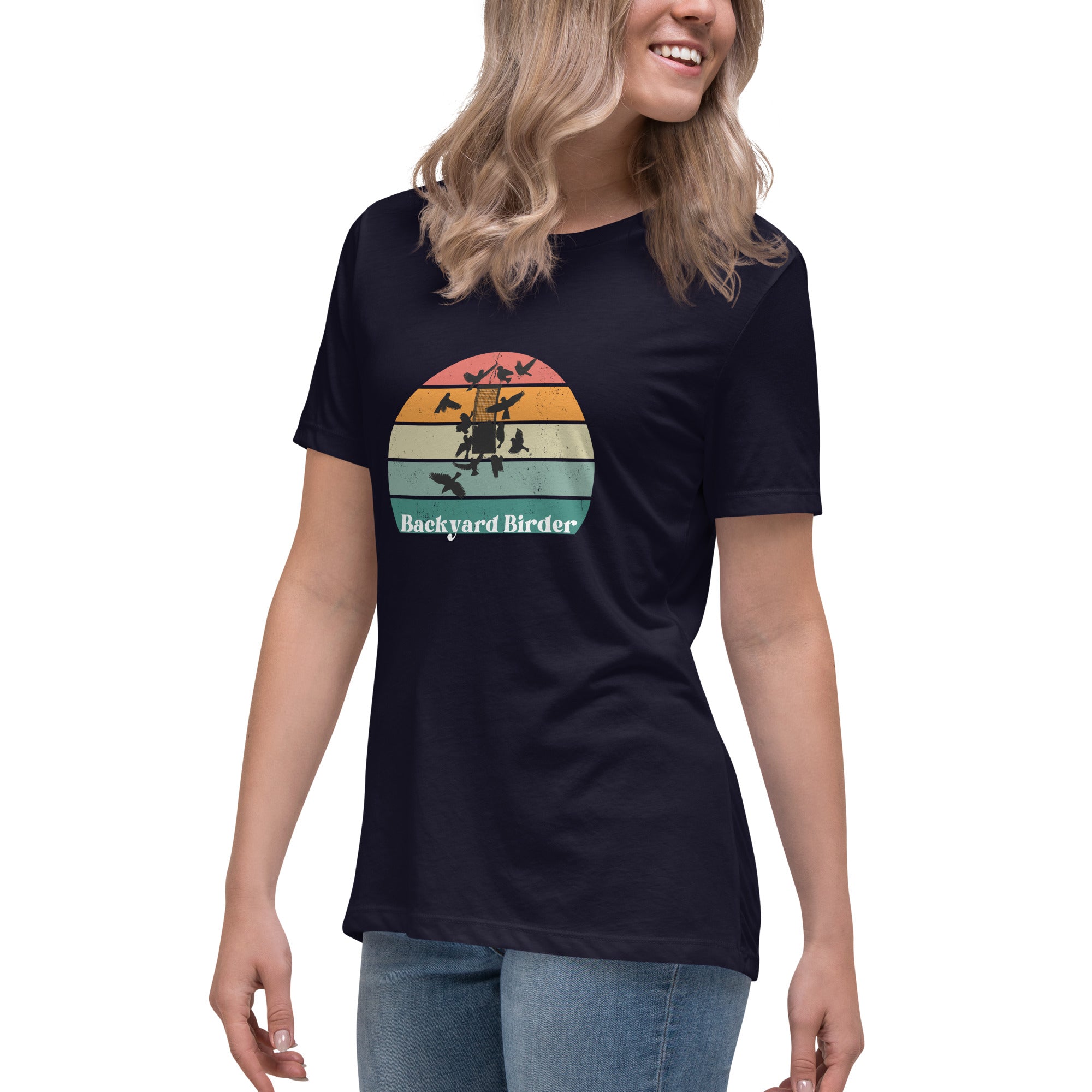 Navy blue women's bird shirt with a retro sun design outlining a bird feeder with the words Backyard Birder. Worn by a woman.