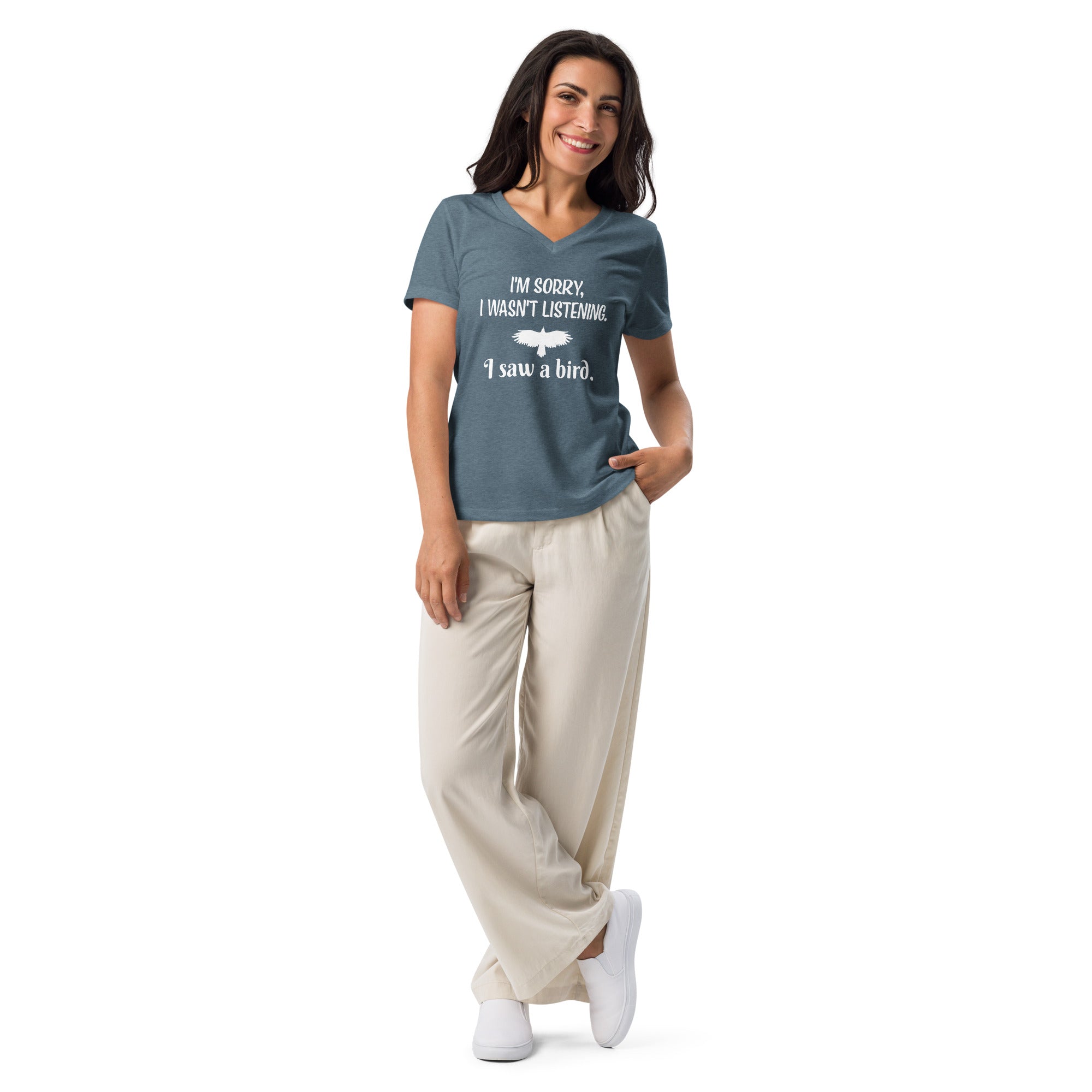 Heather slate blue women's v-neck bird t-shirt with the words I'm sorry I wasn't listening, I saw a bird. And a graphic of a bird flying. Worn by a woman.