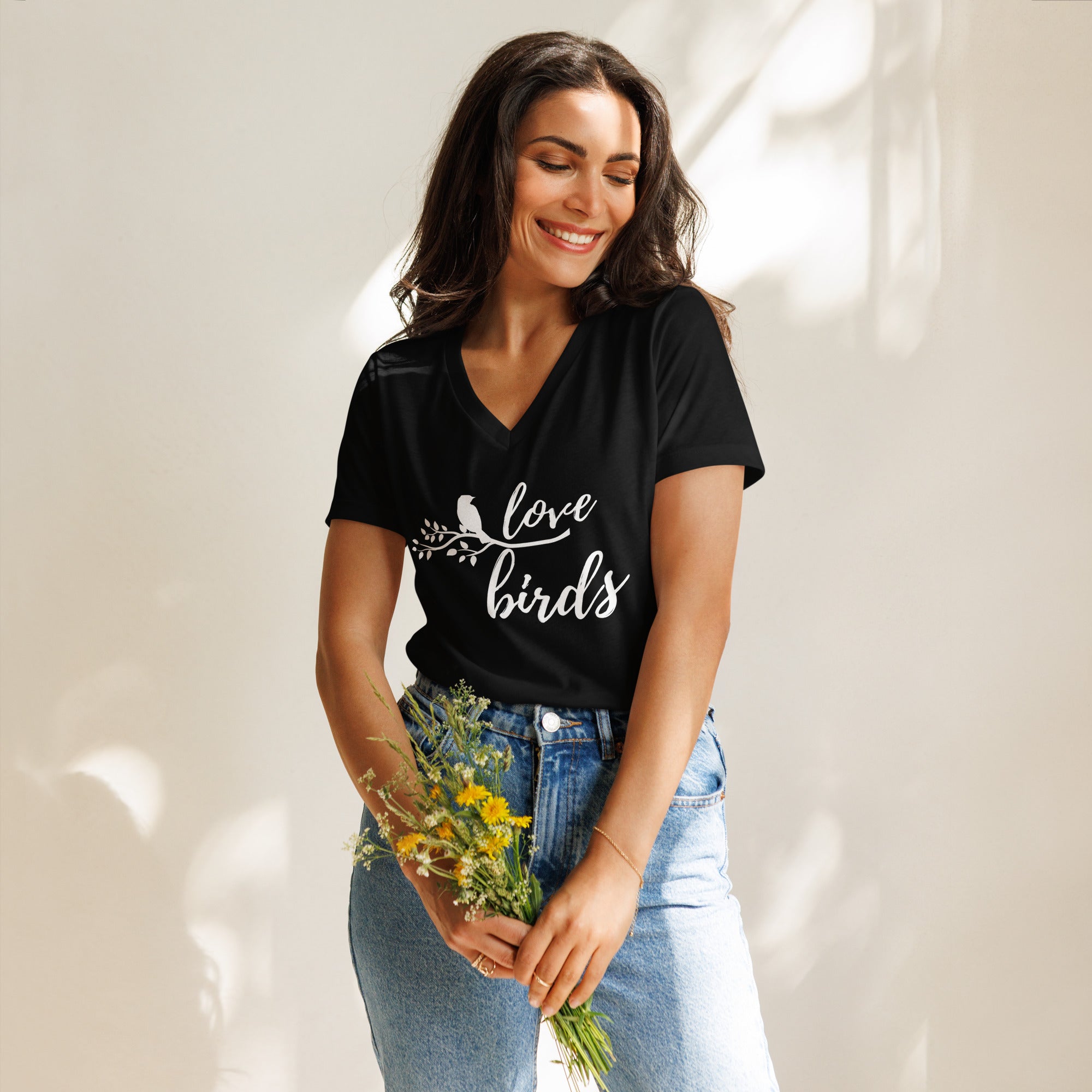 Black women's v-neck birding t-shirt with the words Love birds and a graphic of a bird on a branch in white. Worn by a woman.