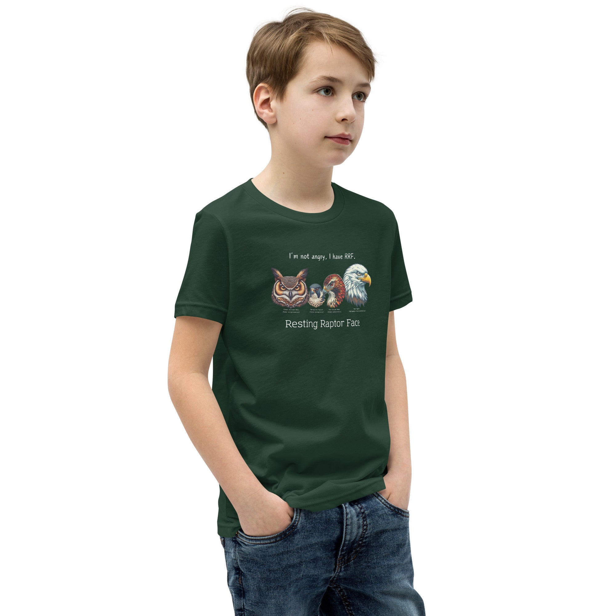 A forest green youth bird shirt with a great horned owl, a peregrine falcon, a red-tailed hawk and a bald eagle. The shirt has text that says, I'm not angry, I have RRF. Resting Raptor Face. Worn by a boy.