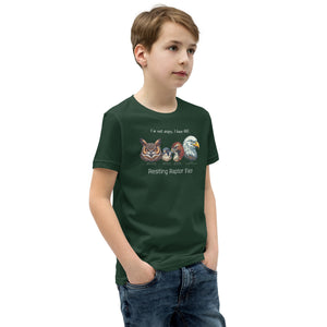 A forest green kid's bird shirt with a great horned owl, a peregrine falcon, a red-tailed hawk and a bald eagle. The shirt has text that says, I'm not angry, I have RRF. Resting Raptor Face. Worn by a boy.