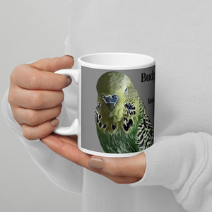 White 11 ounce coffee mug with an illustrated lifelike picture of a green and yellow budgie  on a grey background and next to the word budgerigar in other languages.